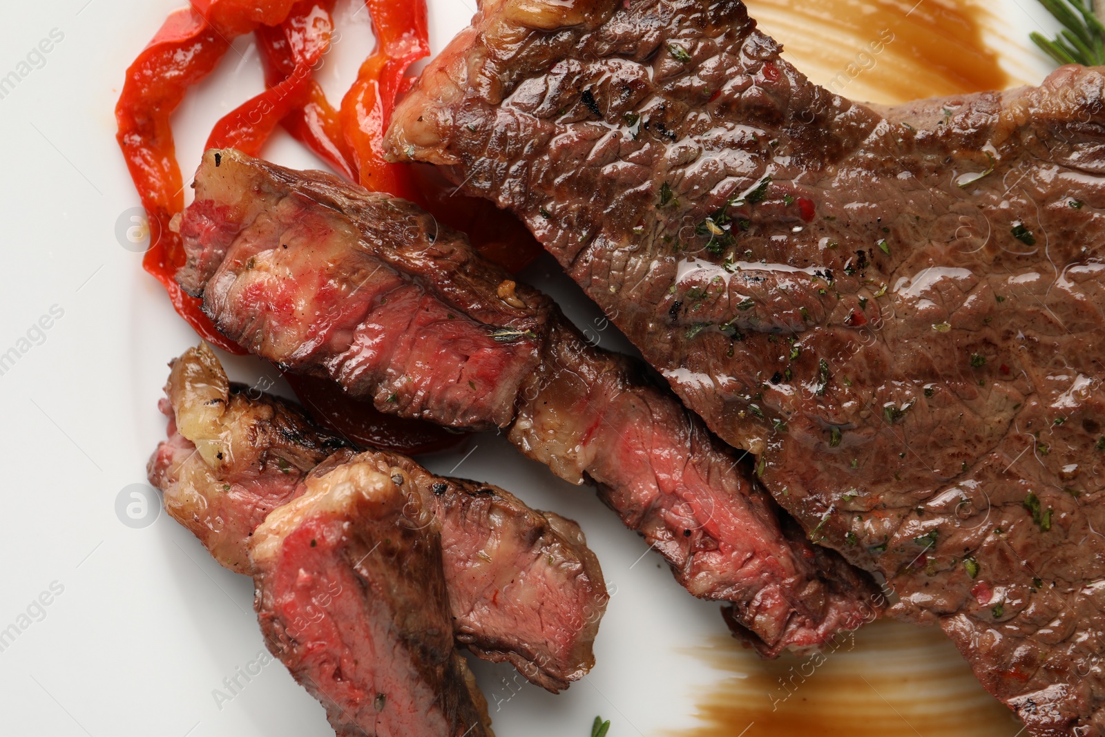 Photo of Delicious grilled beef steak with pepper and spices served on plate, top view