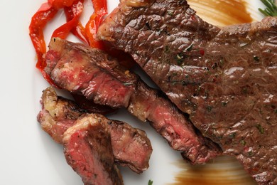 Delicious grilled beef steak with pepper and spices served on plate, top view