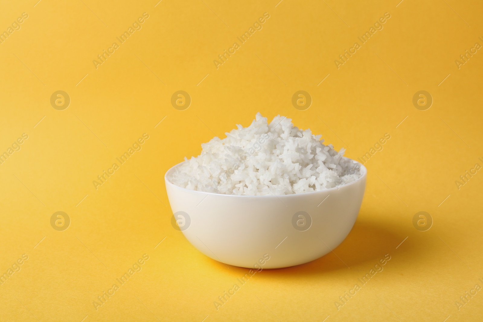 Photo of Bowl of boiled rice on color background