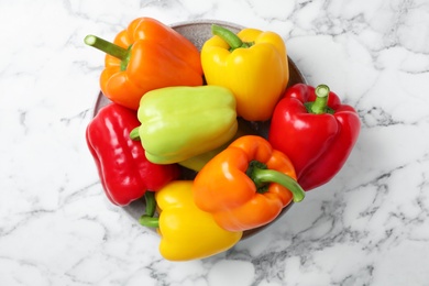 Photo of Plate with fresh bell peppers on marble table, top view