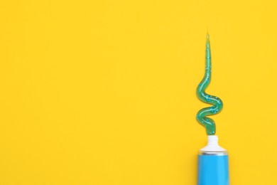 Photo of Tube of toothpaste on yellow background, flat lay. Space for text