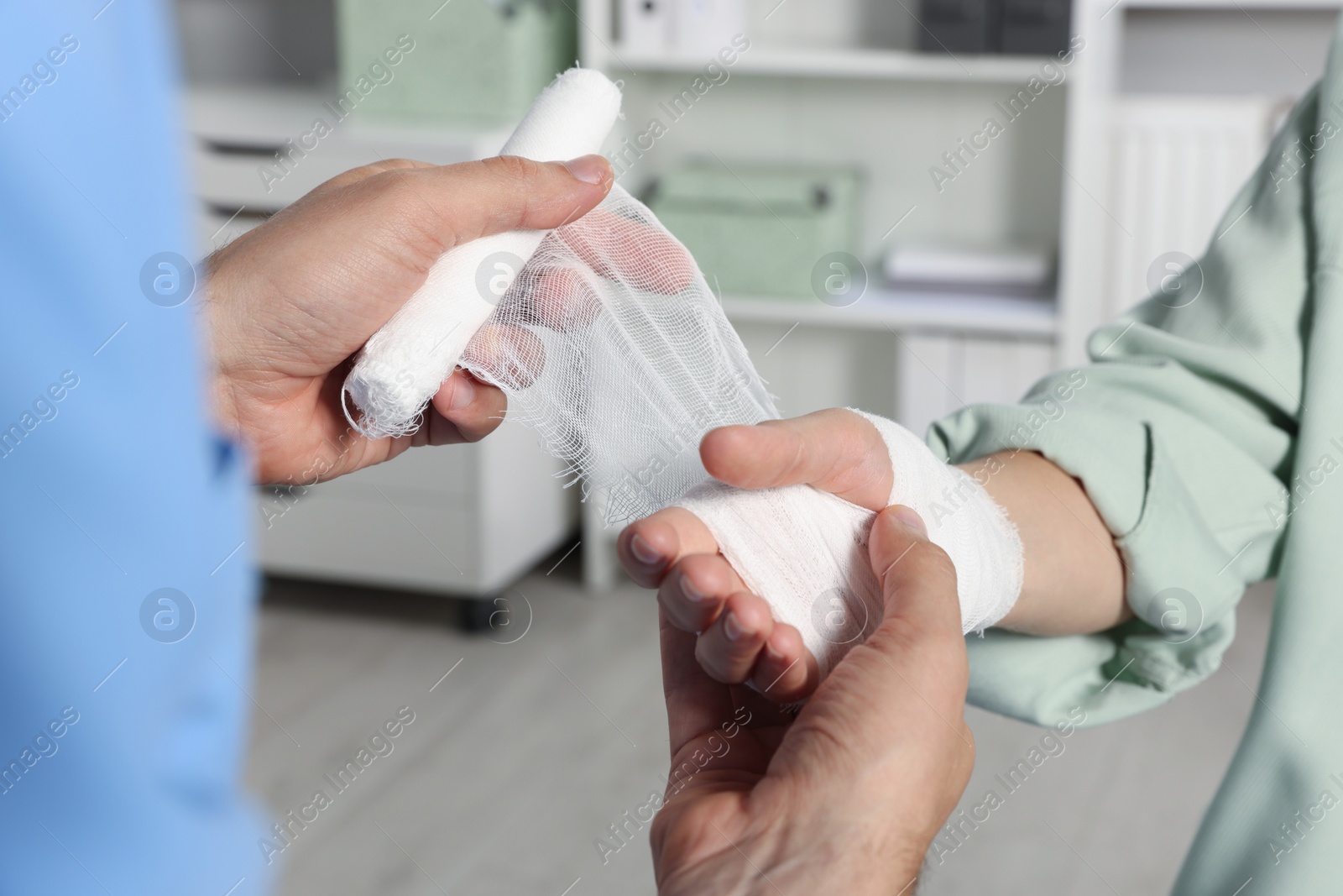 Photo of Doctor applying bandage onto patient's hand in hospital, closeup