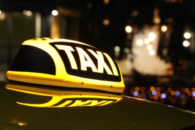 Photo of Taxi car with yellow sign outdoors at night, closeup