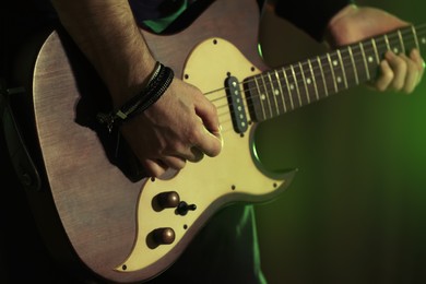 Man playing electric guitar on stage, closeup. Rock music