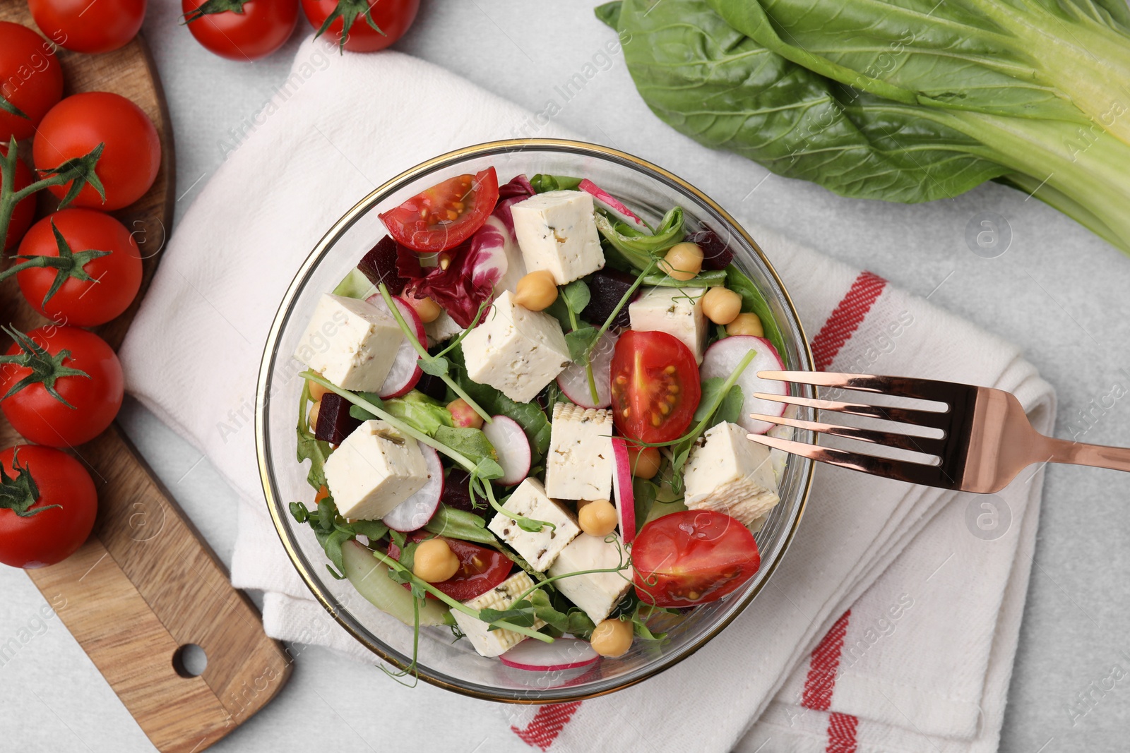 Photo of Tasty salad with tofu and vegetables served on light grey table, flat lay