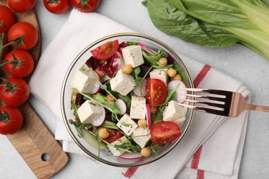 Tasty salad with tofu and vegetables served on light grey table, flat lay