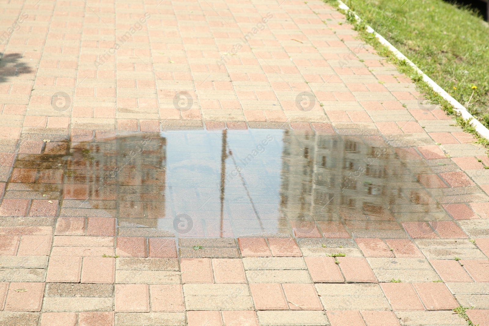 Photo of Puddle after rain on street tiles outdoors