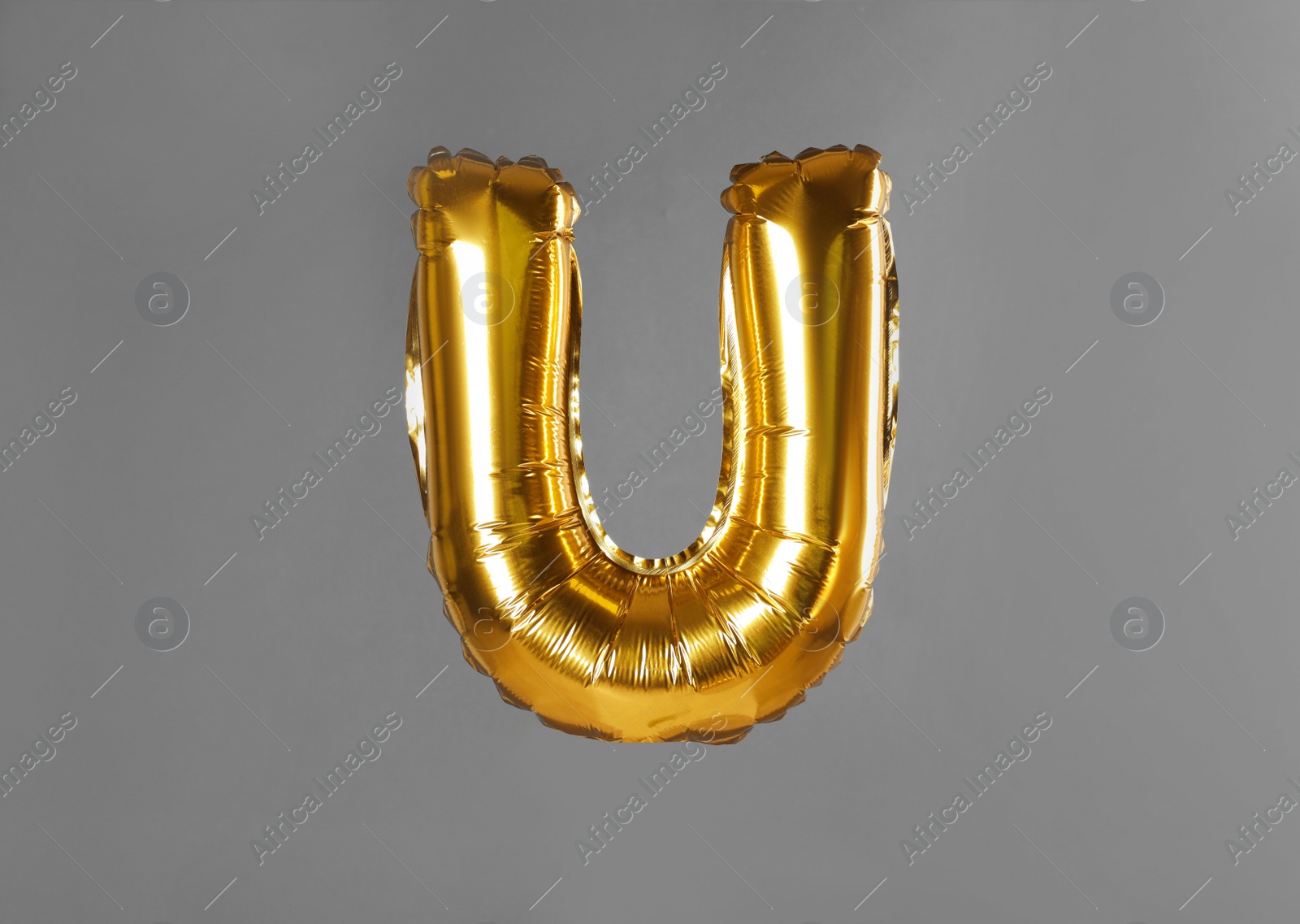 Photo of Golden letter U balloon on grey background