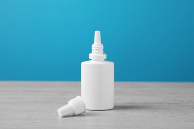Photo of Nasal spray on white wooden table against light blue background