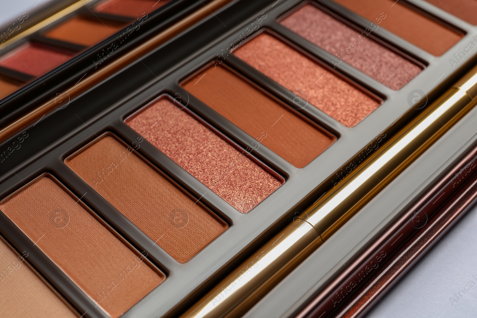 Photo of Beautiful eye shadow palette with brush on white table, closeup