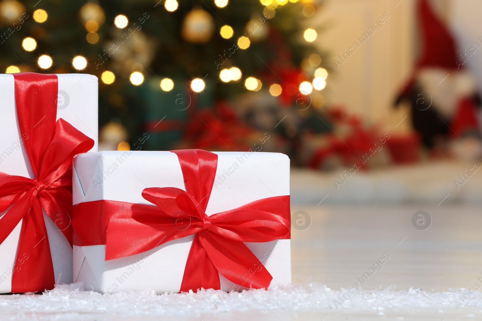 Photo of Gift boxes on floor near Christmas tree in room, space for text