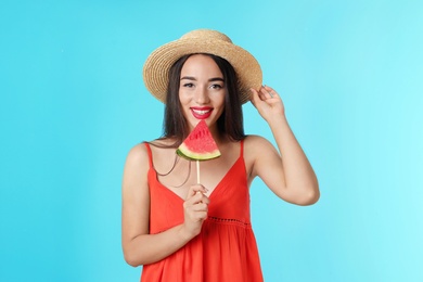 Photo of Beautiful young woman posing with watermelon on color background