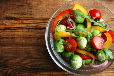 Tasty salad with Brussels sprouts on wooden table, top view. Space for text