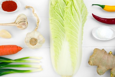 Photo of Flat lay composition with fresh Chinese cabbage and ingredients on white wooden table