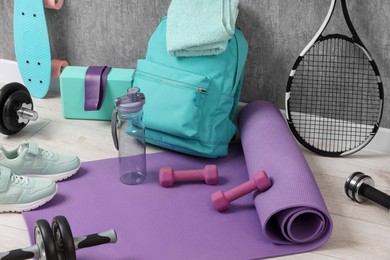 Photo of Many different sports equipment near grey wall indoors