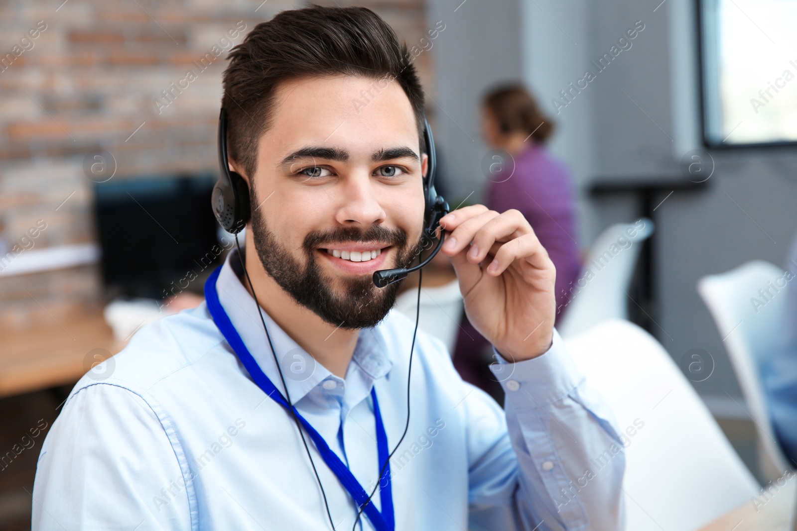 Photo of Technical support operator working with headset in office