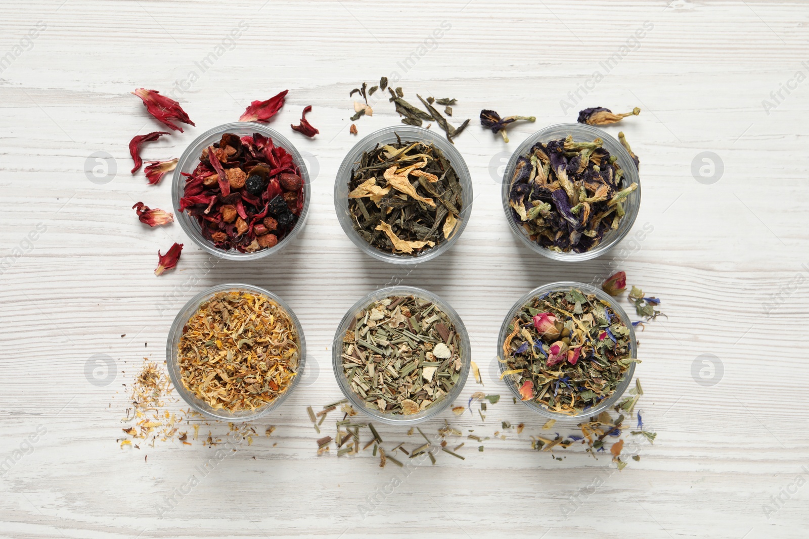 Photo of Flat lay composition with different dry teas on white wooden table