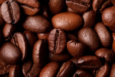 Aromatic roasted coffee beans as background, top view