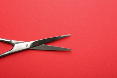 Photo of Pair of sharp scissors on color background, top view. Space for text