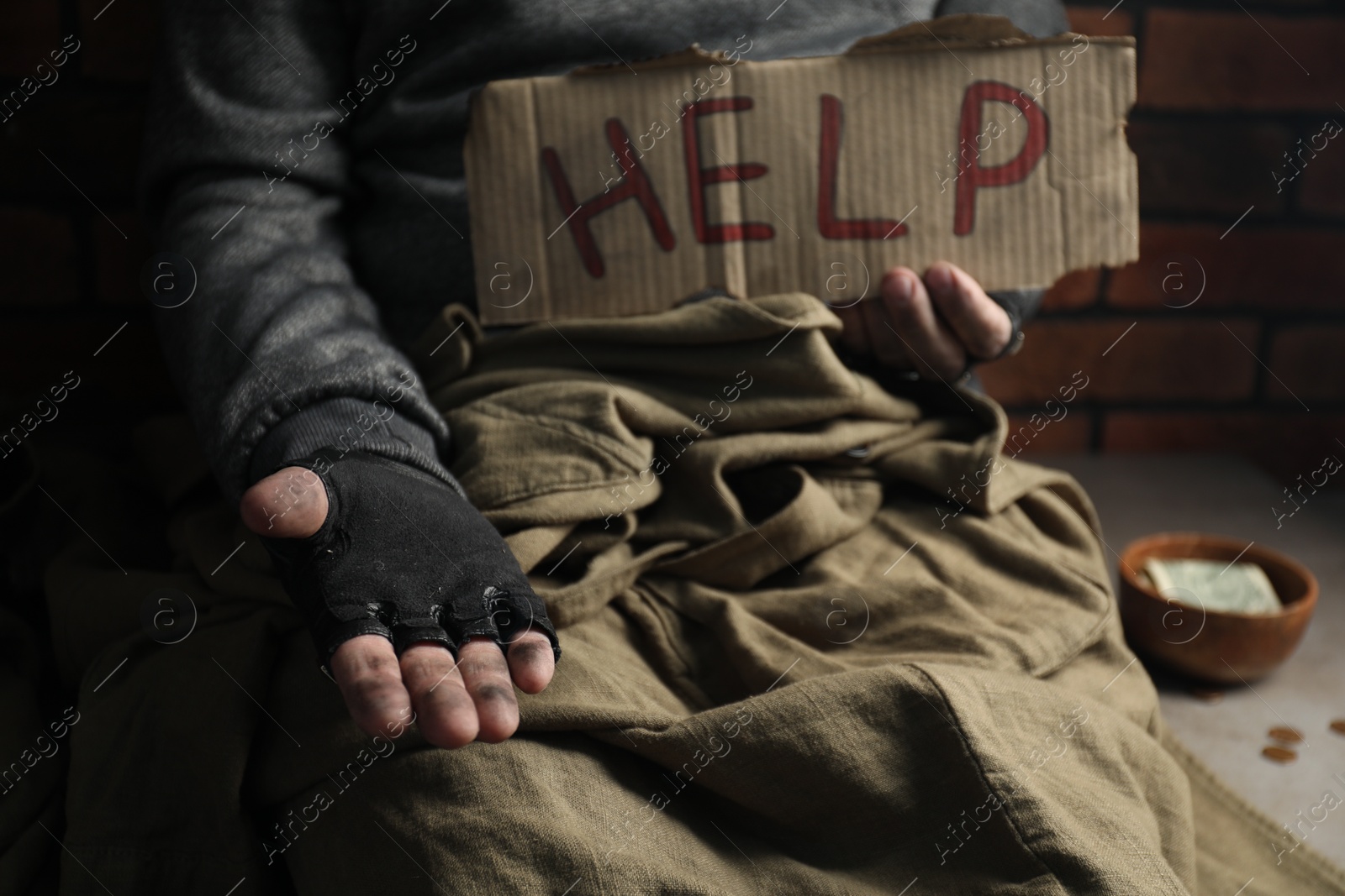 Photo of Poor homeless man with help sign begging for money, closeup. Charity and donation