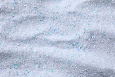 Photo of Laundry powder with color granules as background, top view