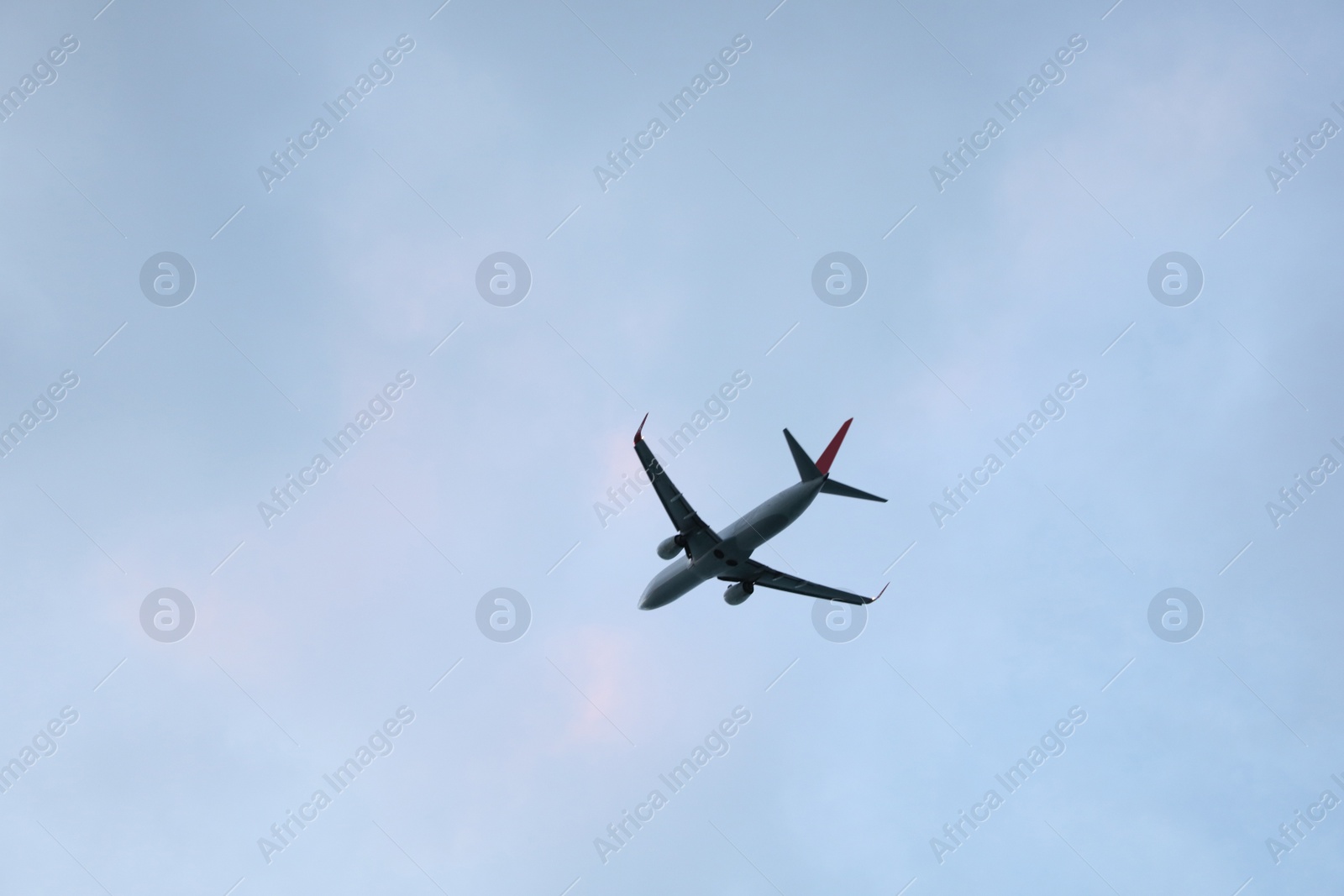 Photo of Modern white airplane flying in clear sky, low angle view