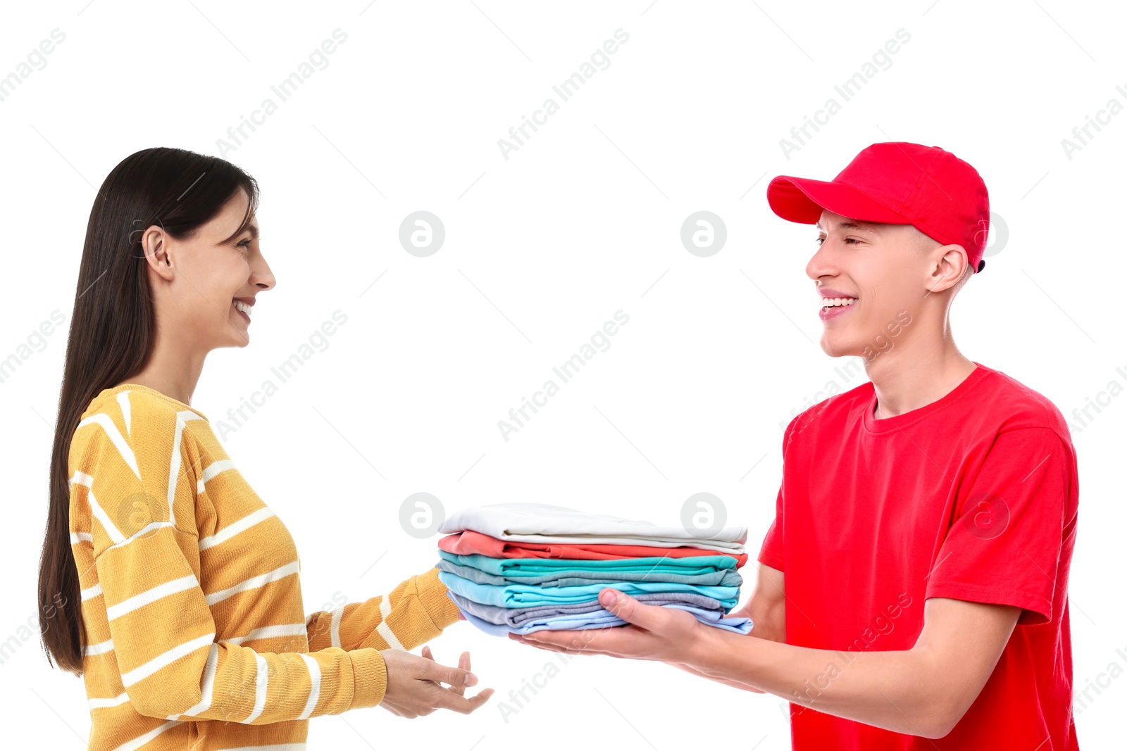 Image of Dry-cleaning delivery. Courier giving folded clothes to woman on white background