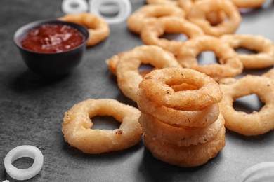 Photo of Stack of fried onion rings on table, closeup