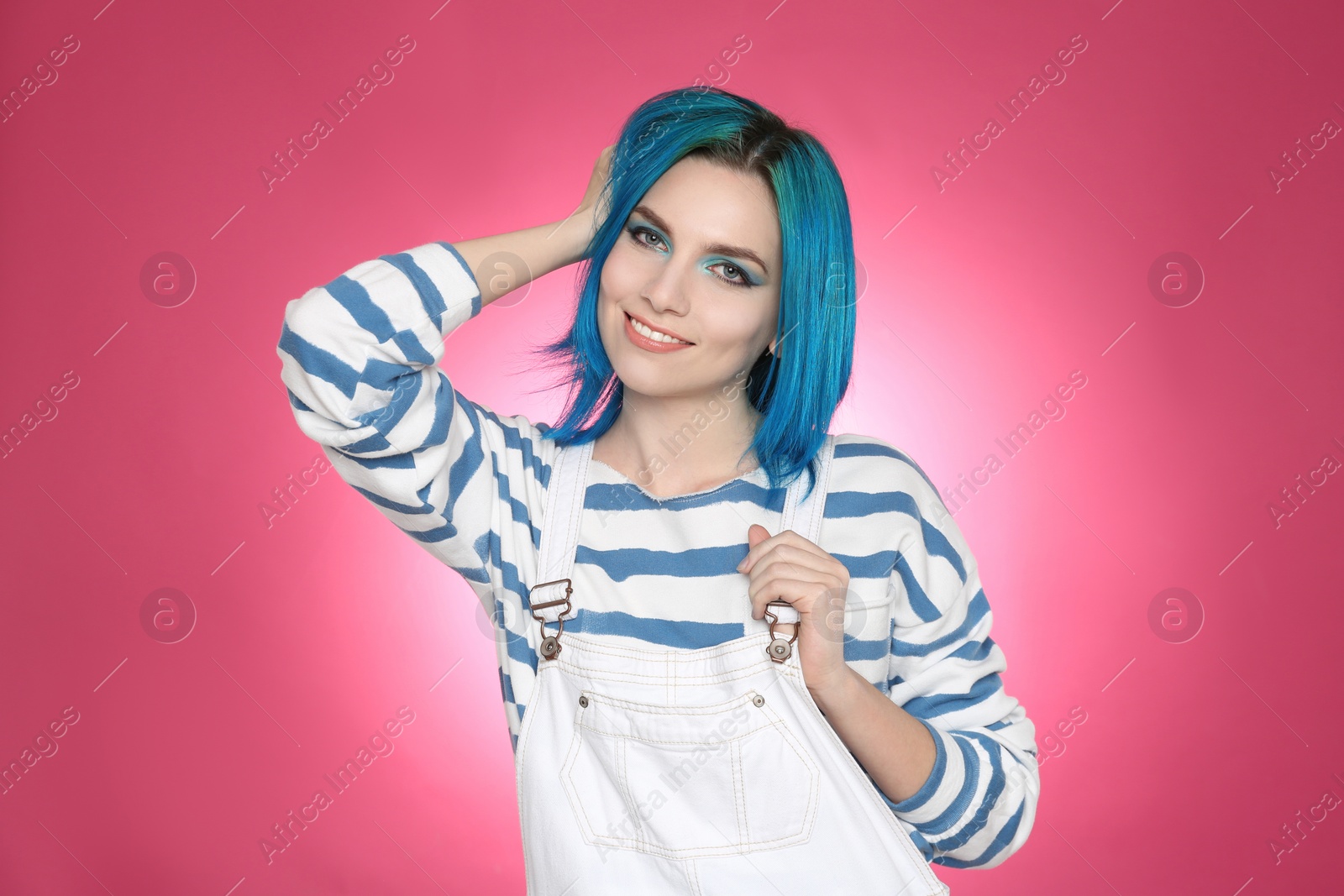 Photo of Young woman with bright dyed hair on pink background