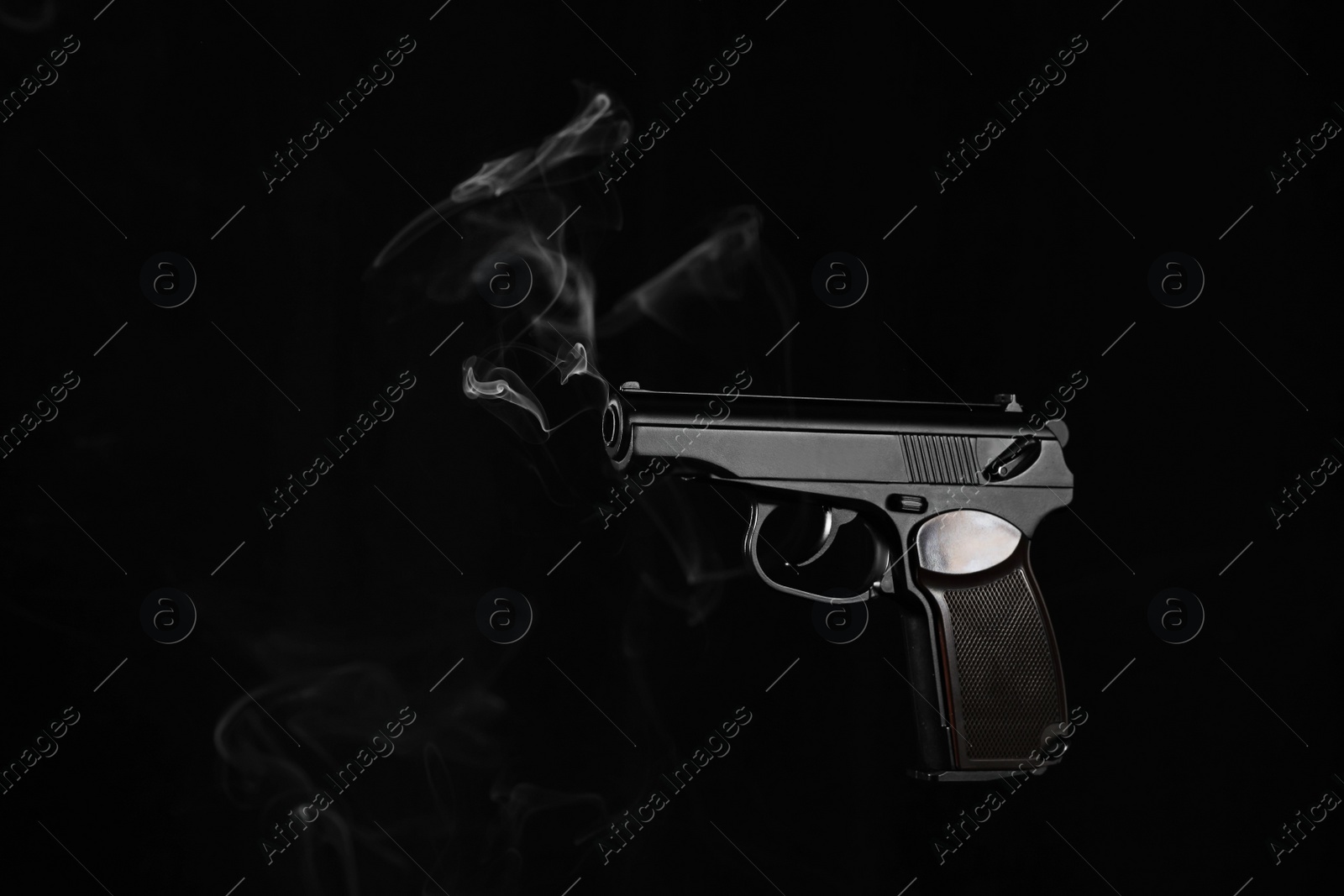 Photo of Handgun with smoke coming out of barrel on dark background, space for text