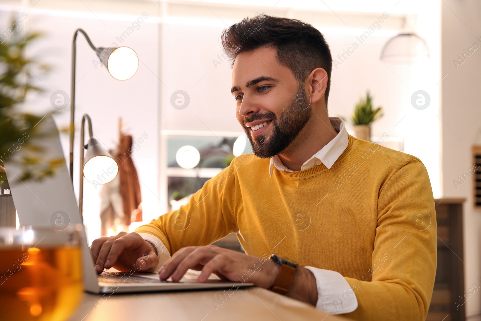 Photo of Man working with laptop at table in cafe