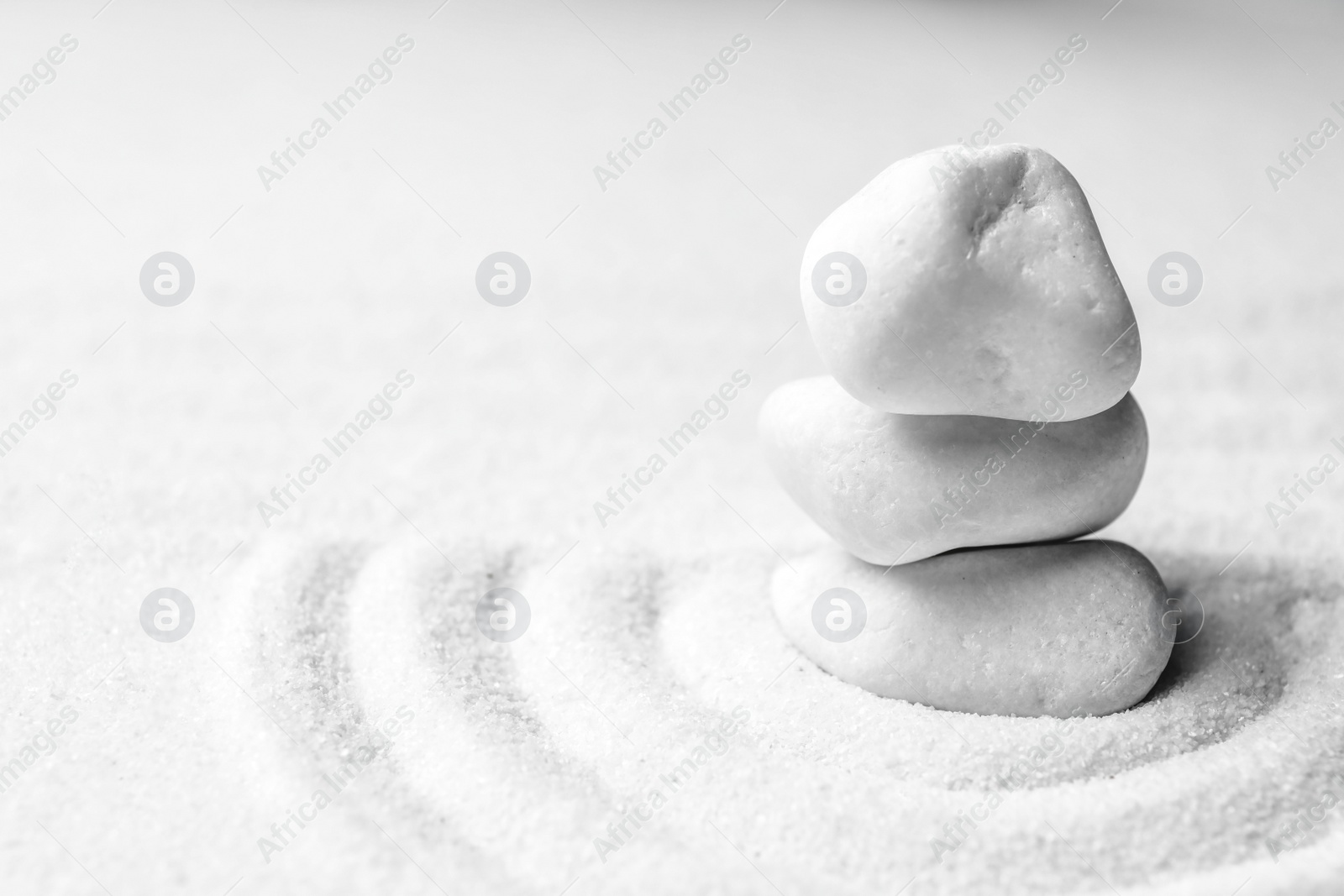 Photo of Stack of white stones on sand with pattern, space for text. Zen, meditation, harmony