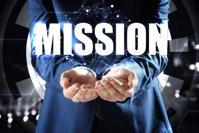 Image of Mission concept. Businessman demonstrating word on blurred background