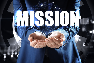 Mission concept. Businessman demonstrating word on blurred background