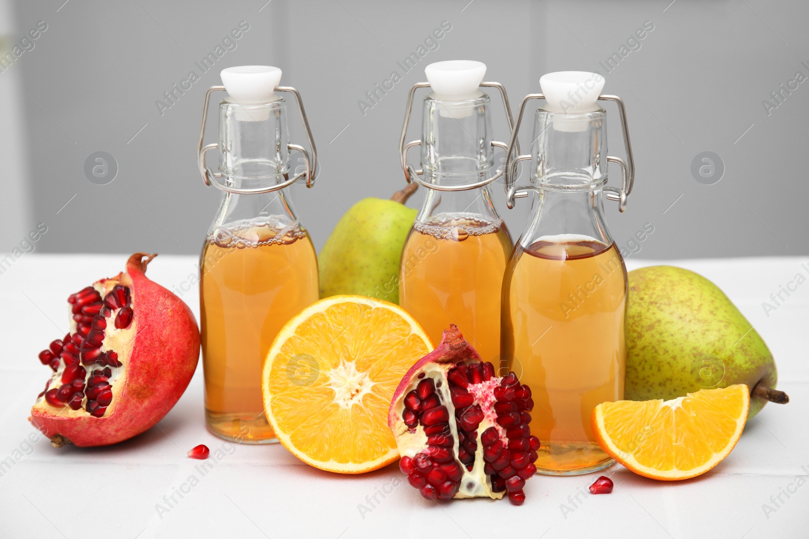 Photo of Homemade fermented kombucha and fresh fruits on white table indoors