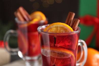 Photo of Glass cup with tasty mulled wine, closeup view