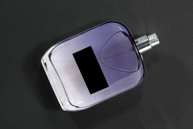 Photo of Luxury men`s perfume in bottle on black background, top view