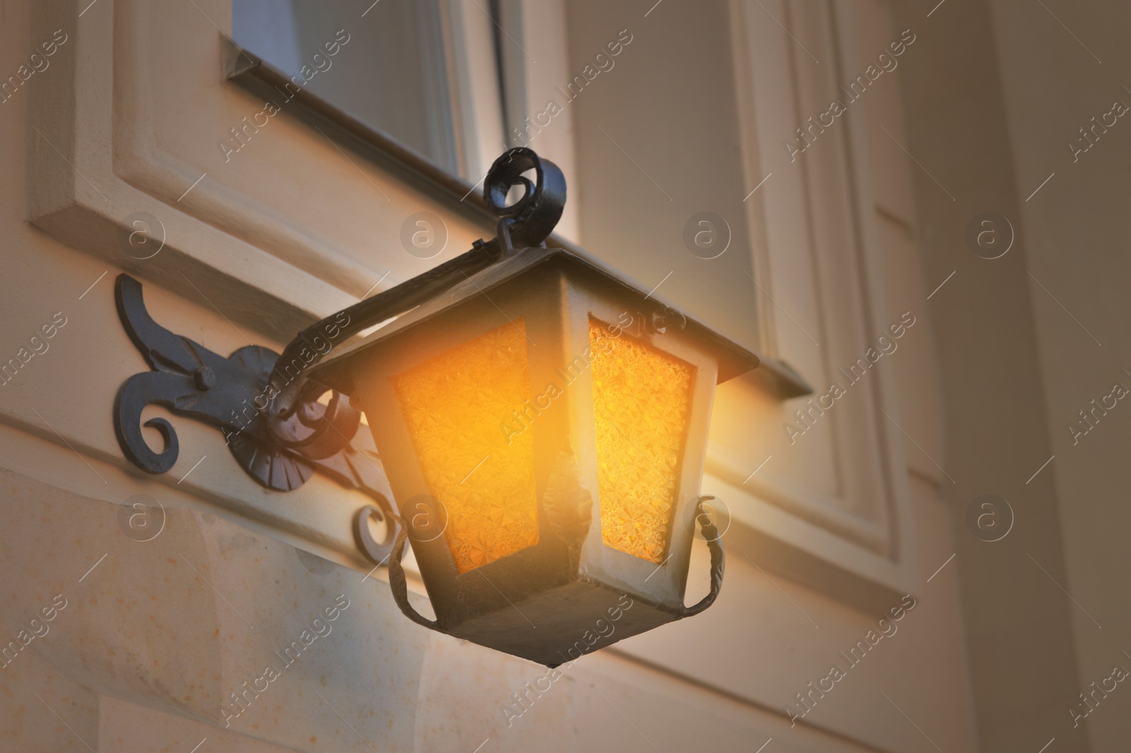 Image of Beautiful old fashioned street lamp lighting on wall of building