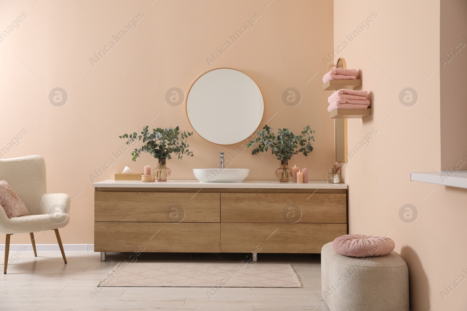 Photo of Modern bathroom interior with stylish mirror, eucalyptus branches, vessel sink and wooden vanity