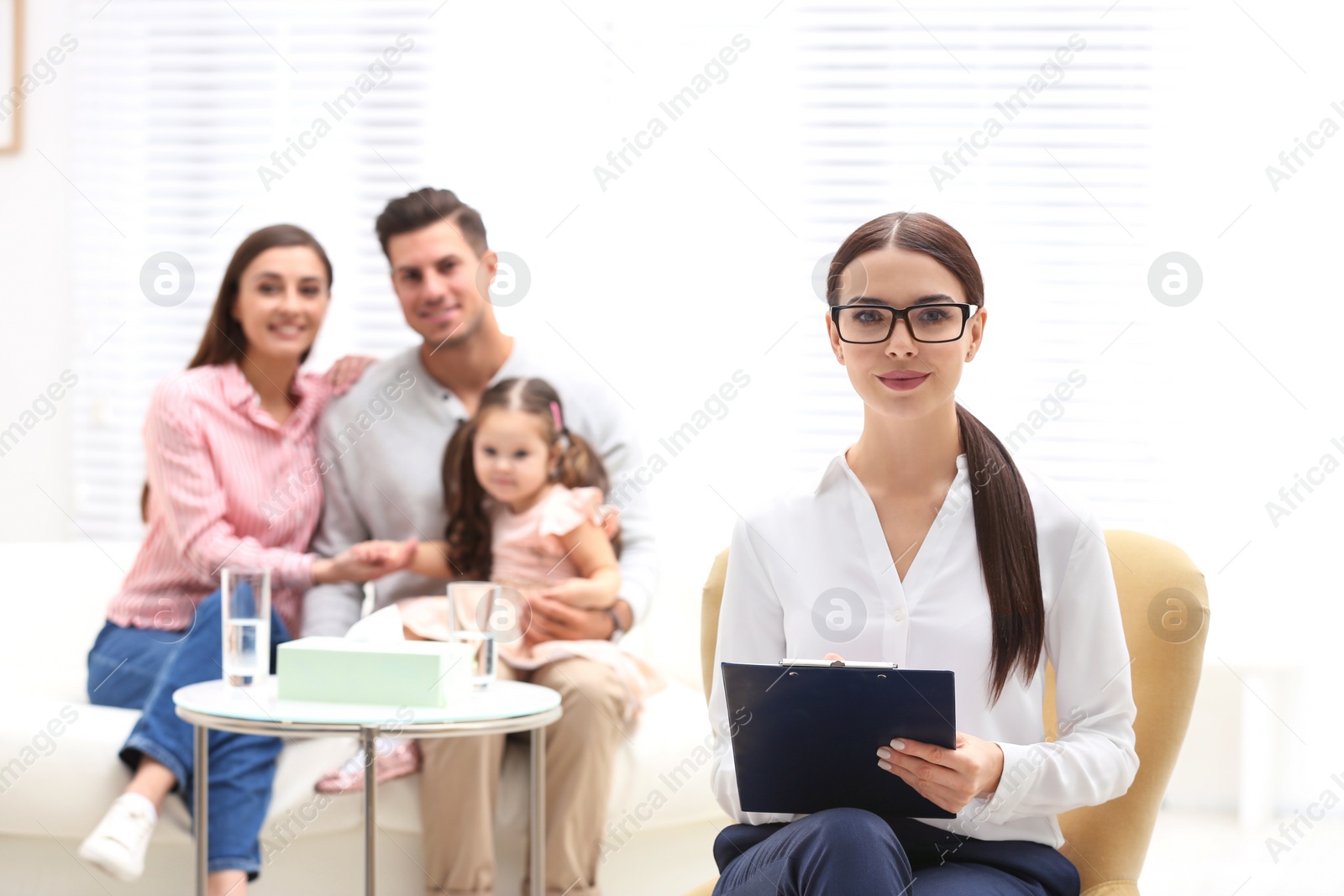 Photo of Professional psychologist and happy family in office