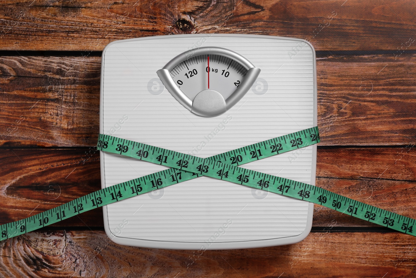 Photo of Scales and measuring tape on wooden background, top view. Weight loss concept
