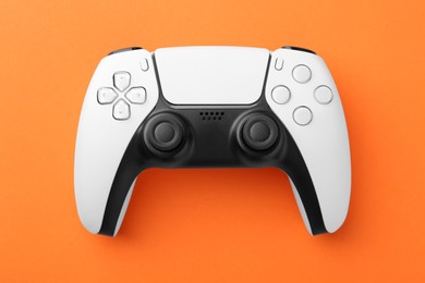 Photo of Wireless game controller on orange background, top view