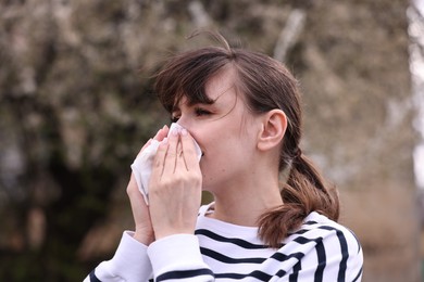 Woman suffering from seasonal allergy in park