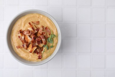 Photo of Delicious lentil soup with bacon and croutons on white tiled table, top view. Space for text