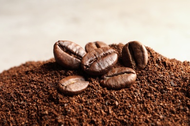 Photo of Coffee grounds and roasted beans on table, closeup