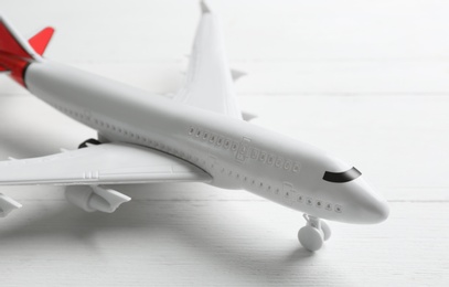 Toy airplane on white wooden background, closeup