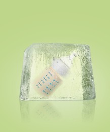 Image of Conservation of genetic material. Baby feeding bottle in ice cube as cryopreservation on light green background