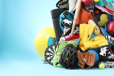 Photo of Many different sports equipment on light blue background