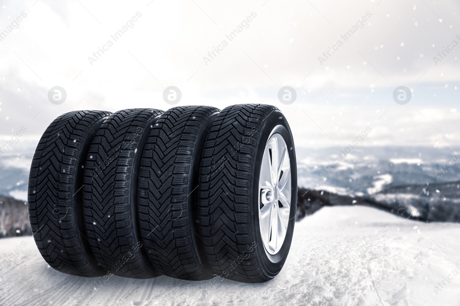 Image of Set of wheels with winter tires outdoors on snow