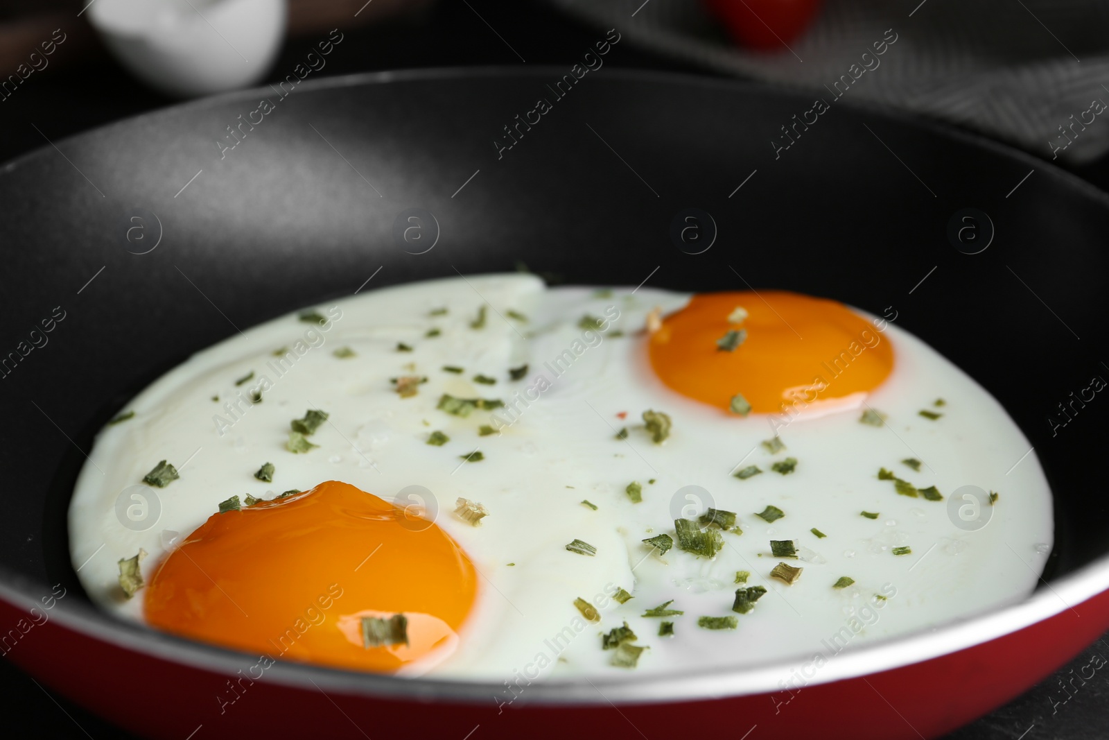 Photo of Tasty cooked eggs with herbs in frying pan, closeup